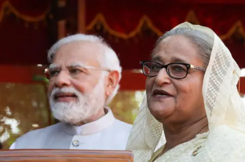 LightRocket via Getty Images NEW DELHI, INDIA - 2022/09/06: Bangladesh Prime Minister Sheikh Hasina (R) speaks to the media during the ceremonial reception with Narendra Modi standing nearby at the Rashtrapati Bhavan in New Delhi. Sheikh Hasina was on a four-day visit to India. Indian Prime Minister Modi and Bangladesh Prime Minister Sheikh Hasina discuss issues related to Defence, Trade, and connectivity. India and Bangladesh are likely to sign pacts on water sharing on the Kushiyara River, training and IT cooperation in Railways, Science, and Space. (Photo by Naveen Sharma/SOPA Images/LightRocket via Getty Images)
