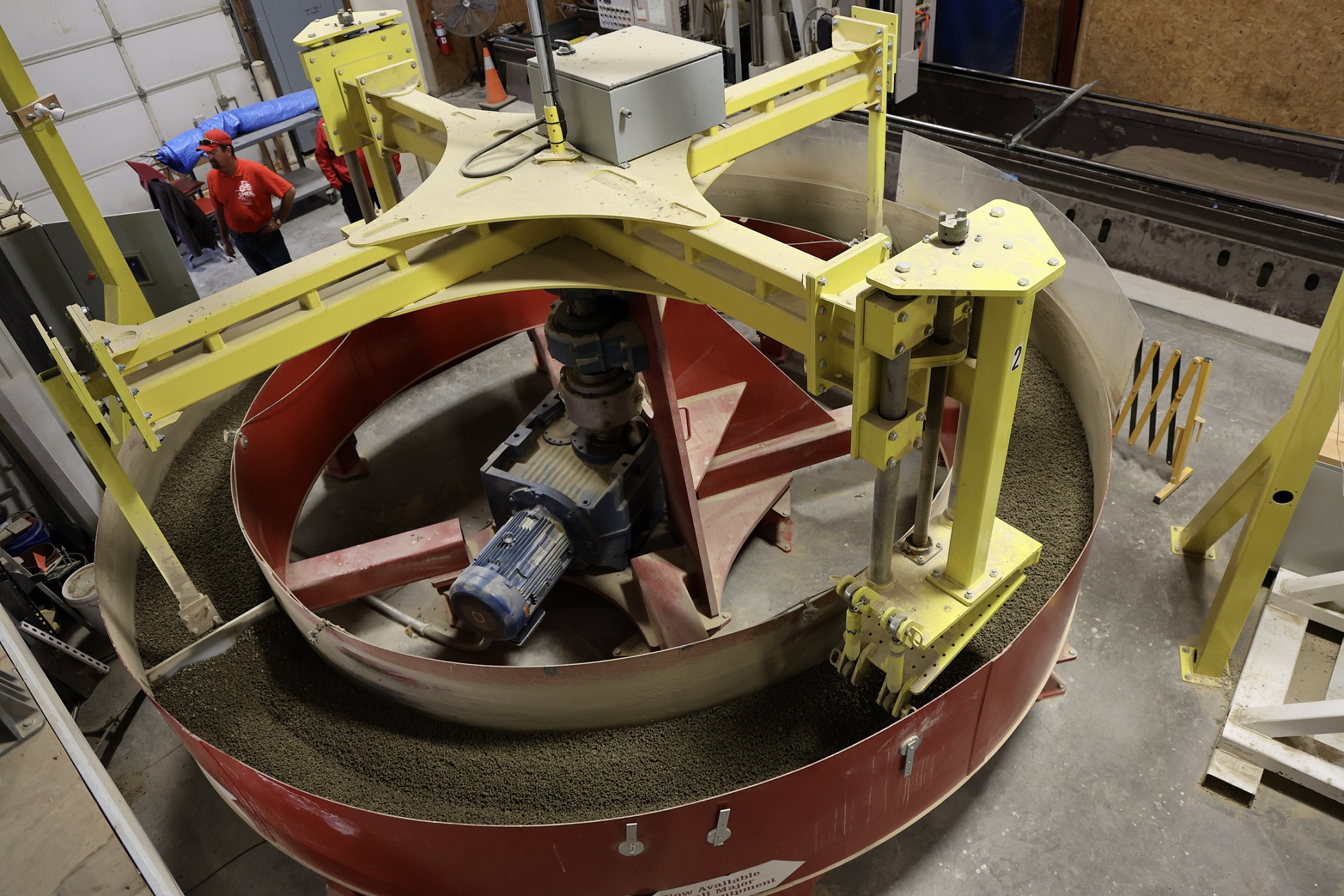 Large circular piece of equipment in soil dynamics lab with people (small) in  background