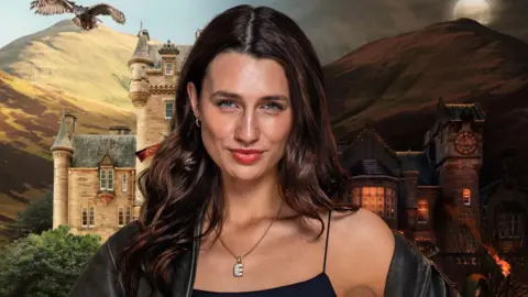 BBC/PA A brown haired woman staring down the barrel of the camera with a slight smirk. She is wearing black clothes with an 'E' shaped necklace. The background is busy with castles and birds.