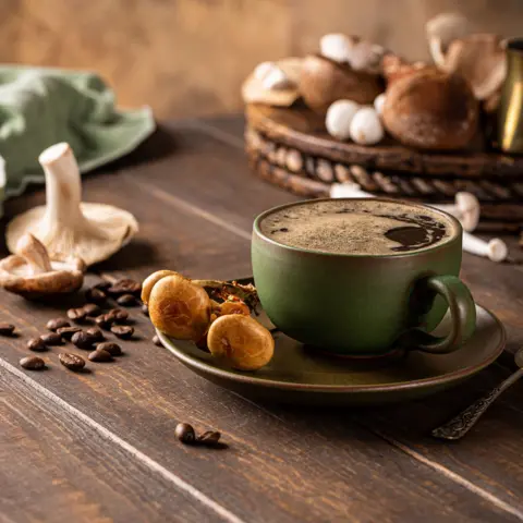 Getty Images Trendy superfood mushroom coffee in green cup on wooden background. 