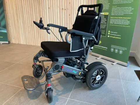 A wheelchair with an electric battery-powered motor.