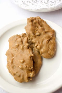 Two clusters of nuts and creamy butter on a plate.