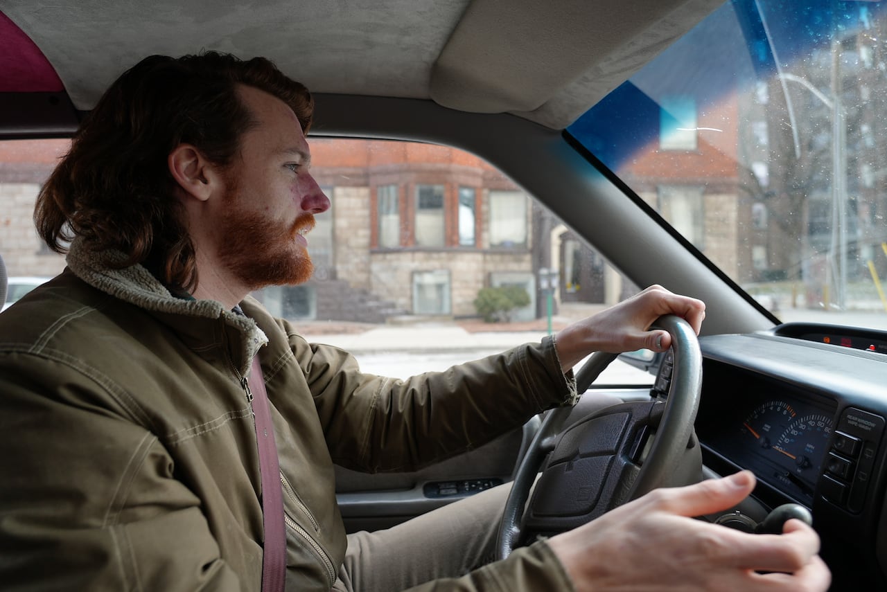 A young man behind the wheel of a vehicle