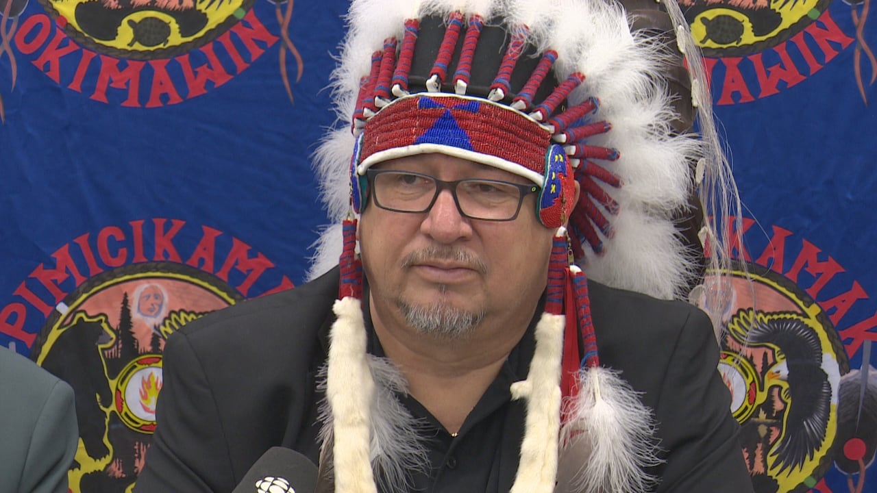 A man in headdress during a press conference.