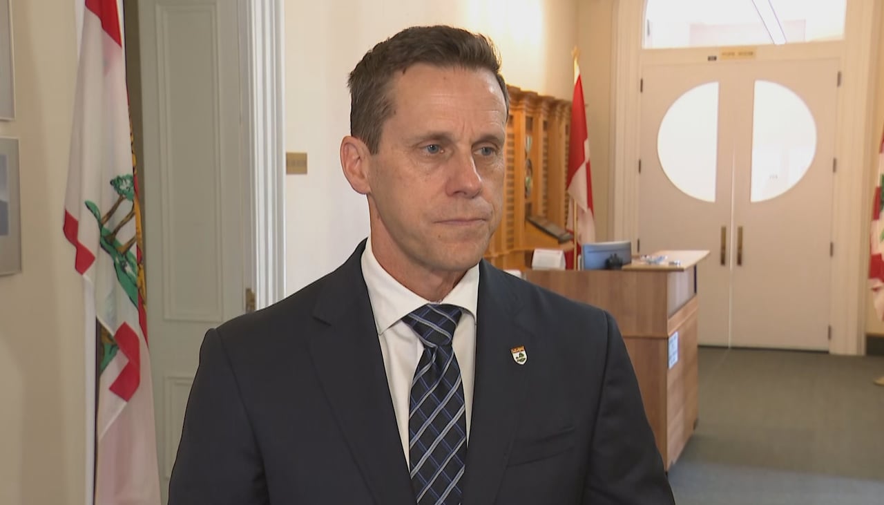 A man in a suit stands in a hallway