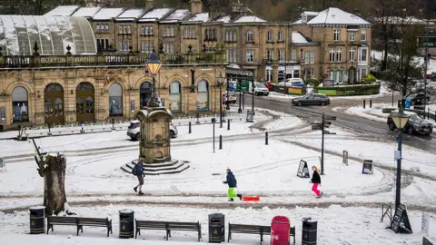 Getty Images An overhead shot of a public square in Buxton. Two children can be seen - one dragging a snow sledge as snow on the ground has turned slushy