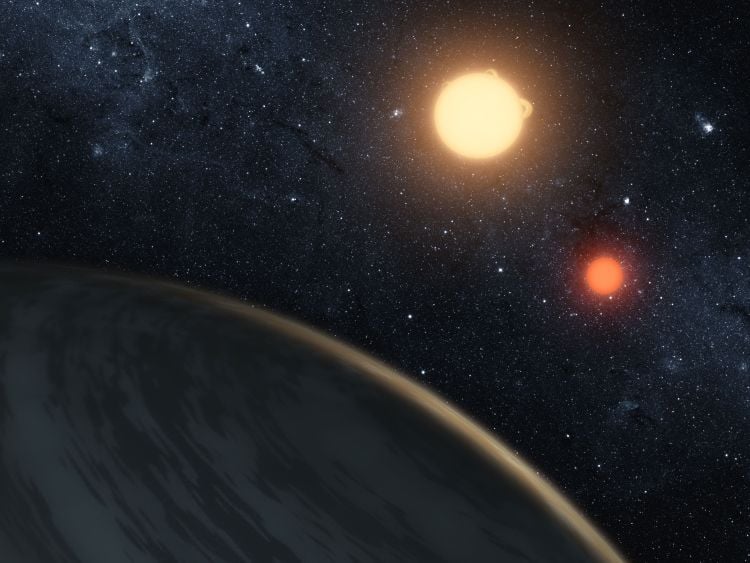 Saturn-mass world discovered orbiting two low-mass stars